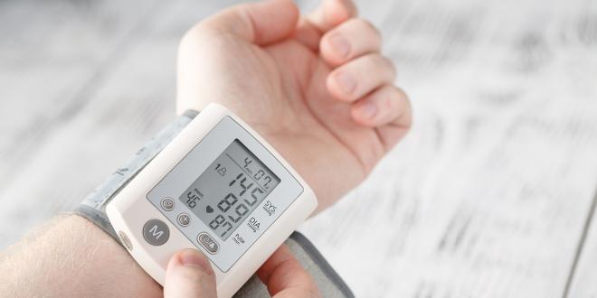 a man checking his blood pressure at home with electronics