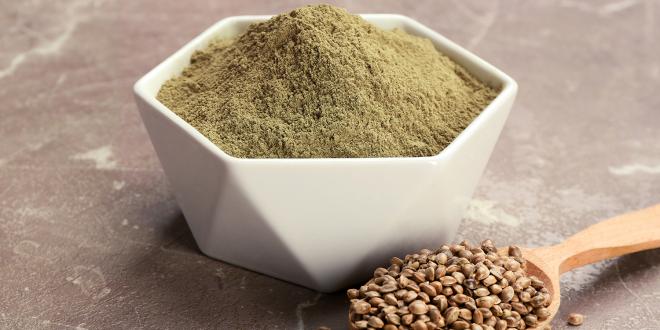 a spoon full of hemp seeds, and a bowl of protein powder