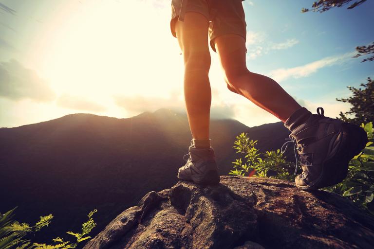 A hiker walking into beautiful sun