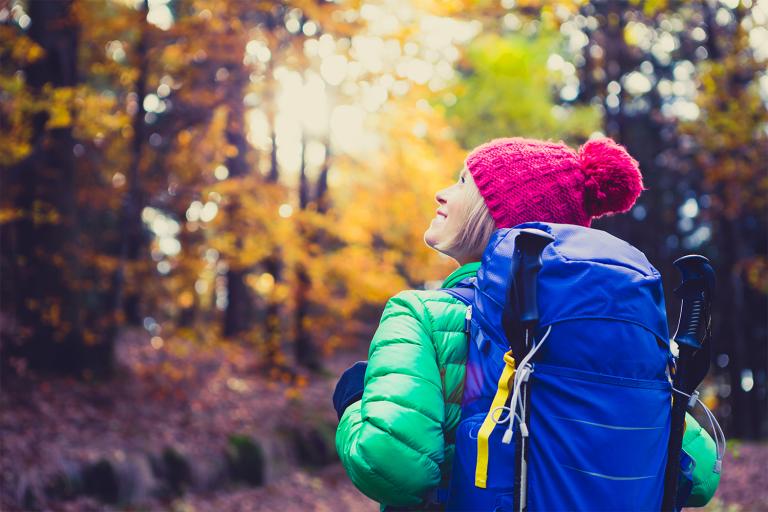 a woman hiking through the fall foliage