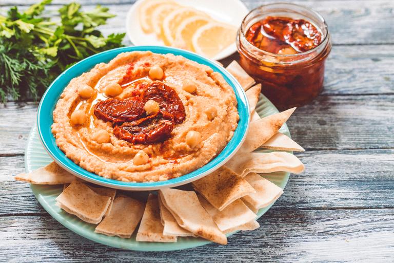 a plate of pita chips and a bowl of hummus